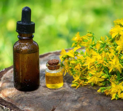 St. John's wort flower oil in a glass bottle. on a wooden background. Selective focus